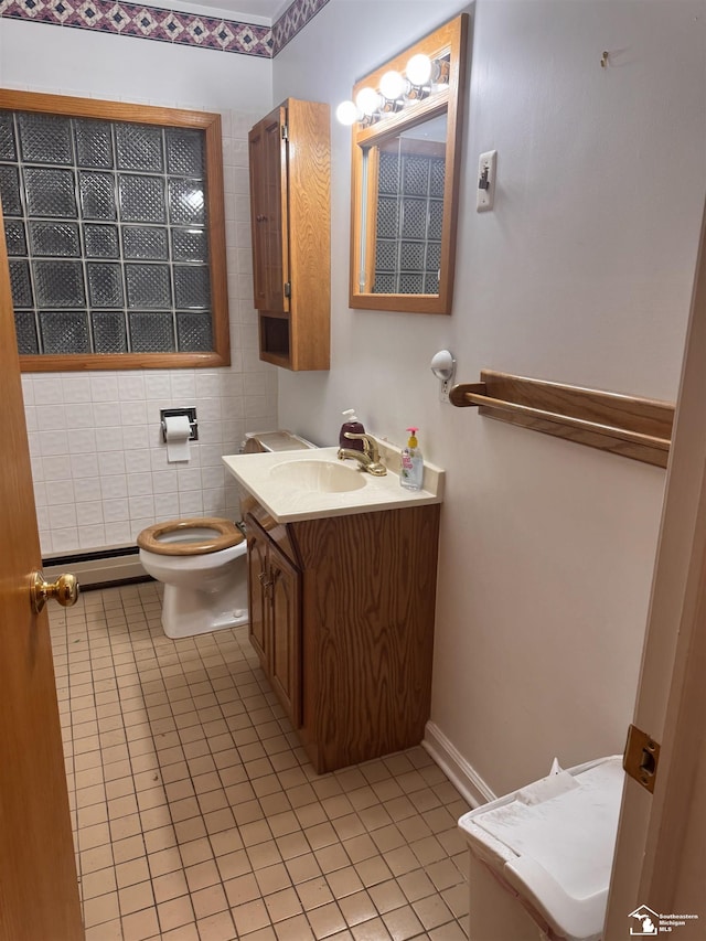 bathroom with a baseboard heating unit, vanity, toilet, and tile patterned floors