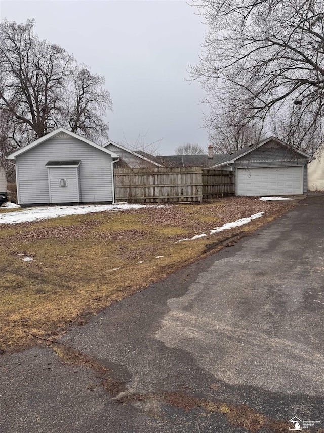 view of yard featuring a garage and an outbuilding