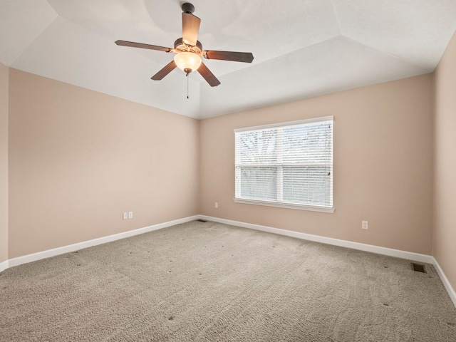 spare room featuring lofted ceiling, light colored carpet, baseboards, and visible vents