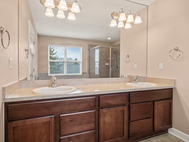 bathroom with a shower stall, double vanity, and a sink