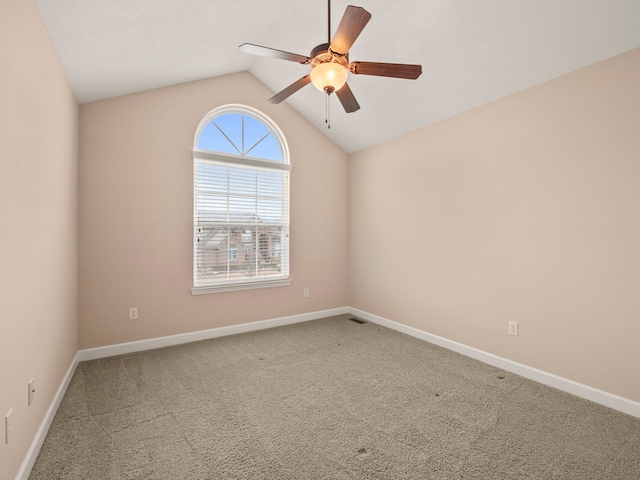 carpeted empty room featuring baseboards, lofted ceiling, and ceiling fan