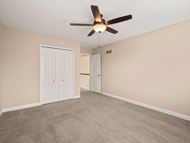 unfurnished bedroom featuring visible vents, ceiling fan, baseboards, carpet, and a closet