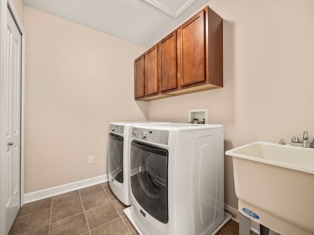 washroom featuring baseboards, cabinet space, a sink, tile patterned flooring, and washer and clothes dryer