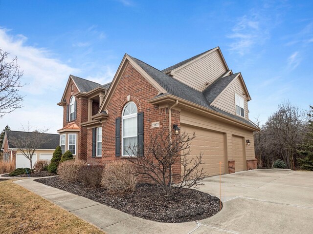 view of home's exterior featuring concrete driveway, an attached garage, brick siding, and a shingled roof