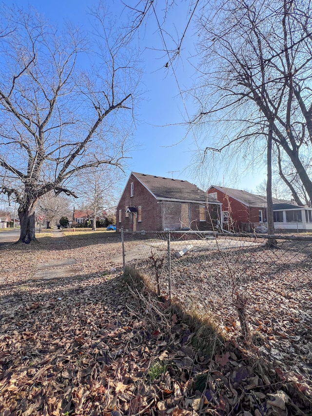 view of property exterior featuring brick siding and fence