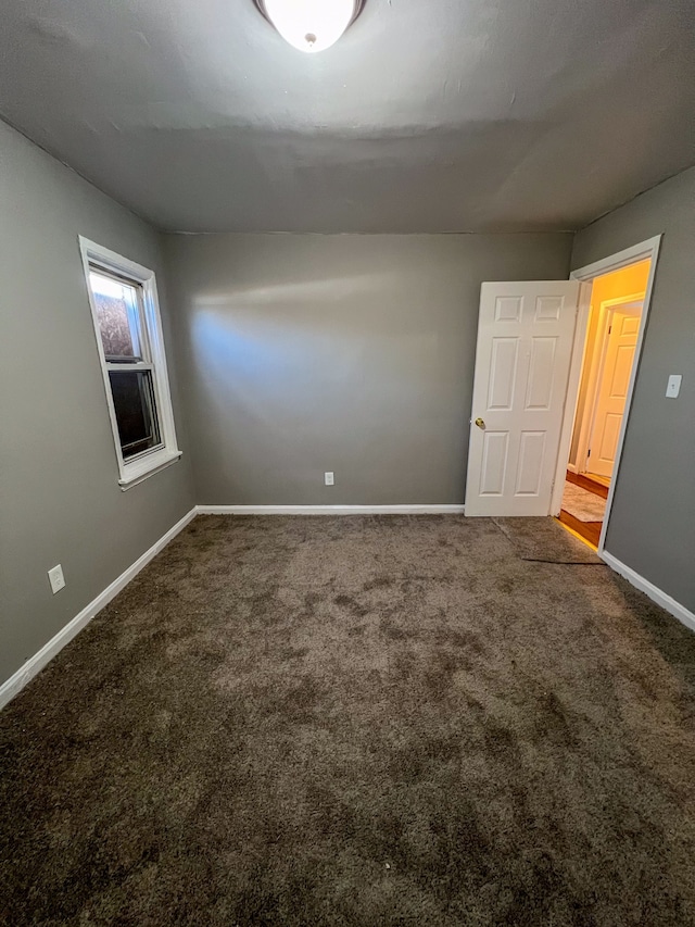 unfurnished room featuring carpet flooring and baseboards