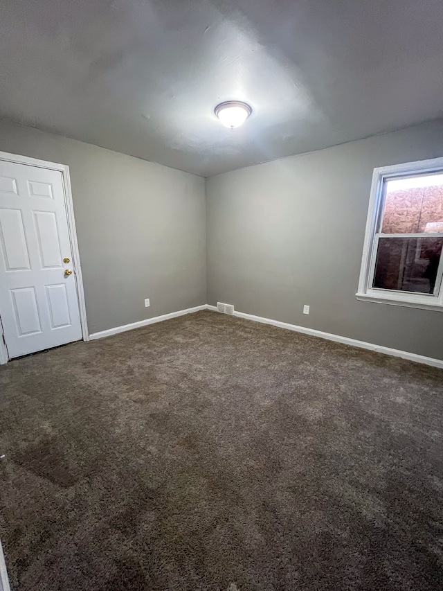 unfurnished room featuring carpet, visible vents, and baseboards