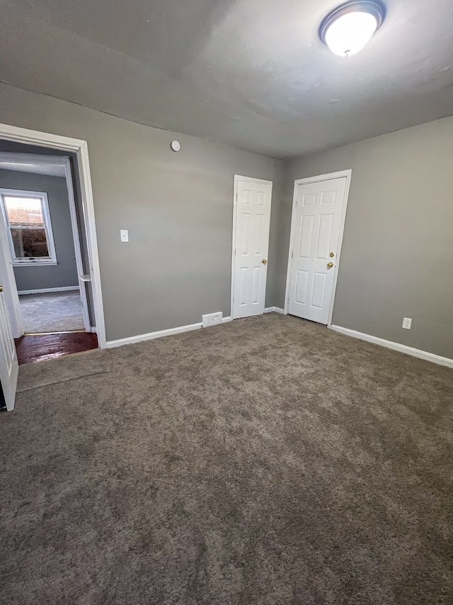 carpeted spare room featuring baseboards