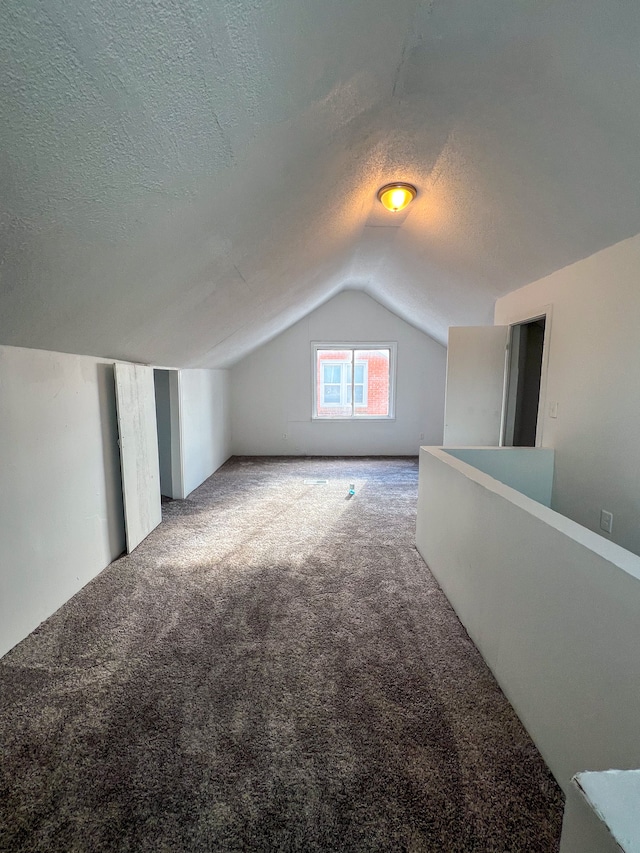 bonus room featuring a textured ceiling, carpet floors, and vaulted ceiling