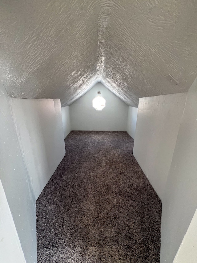 bonus room with a textured ceiling, vaulted ceiling, and carpet flooring