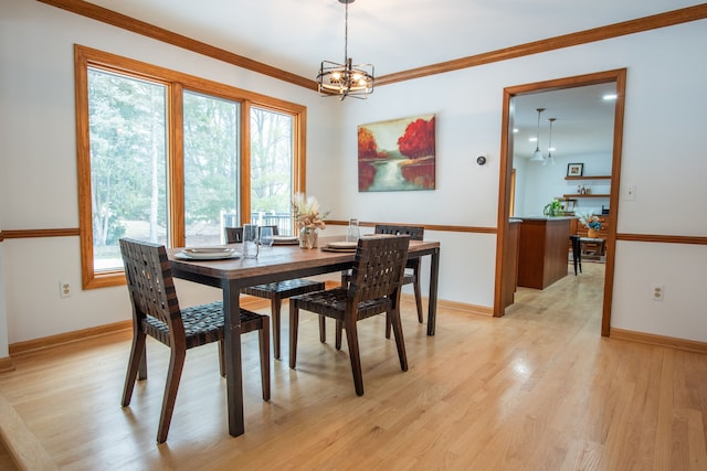 dining area featuring baseboards, a notable chandelier, light wood-style flooring, and crown molding