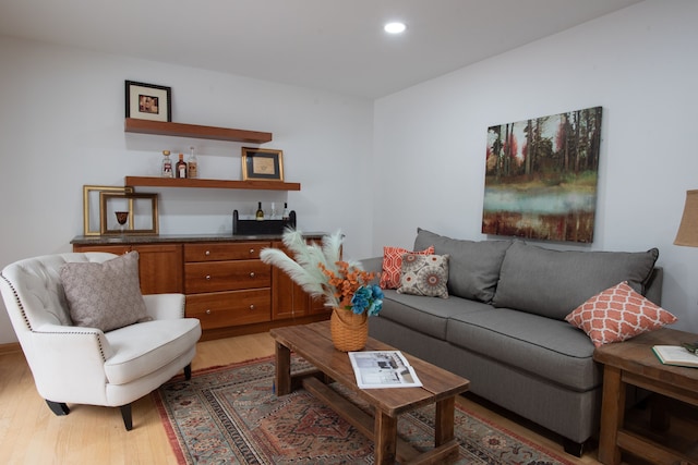 living area featuring light wood-style floors, indoor bar, and recessed lighting