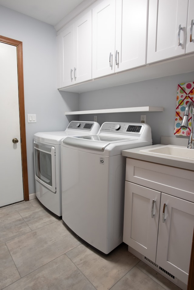 laundry room featuring cabinet space, a sink, and washing machine and clothes dryer