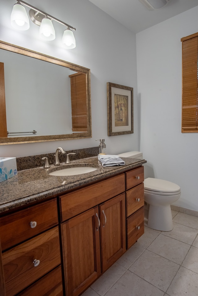 bathroom featuring toilet, tile patterned flooring, and vanity