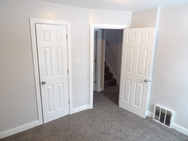 unfurnished bedroom with carpet floors, visible vents, and baseboards