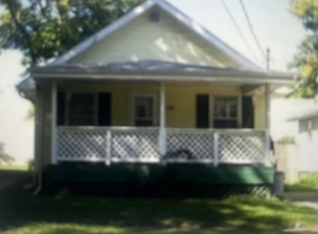 view of front of home with a porch and a front yard