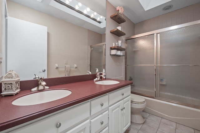 bathroom featuring tile patterned floors, double vanity, a skylight, and a sink