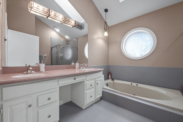 bathroom with a jetted tub, lofted ceiling with skylight, double vanity, a stall shower, and a sink