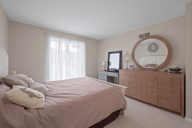 bedroom with visible vents and light carpet