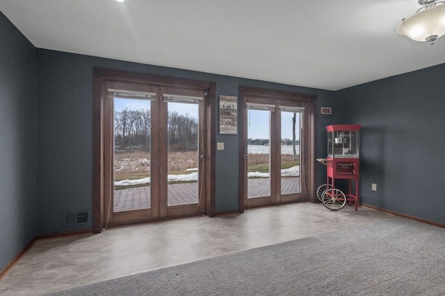 doorway featuring visible vents, baseboards, and carpet floors