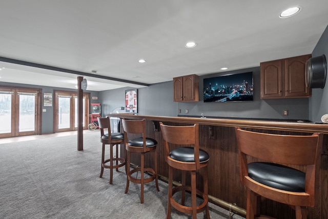 bar with indoor wet bar, recessed lighting, and light carpet