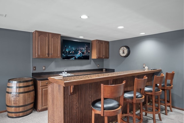 bar with visible vents, light colored carpet, recessed lighting, wet bar, and a sink