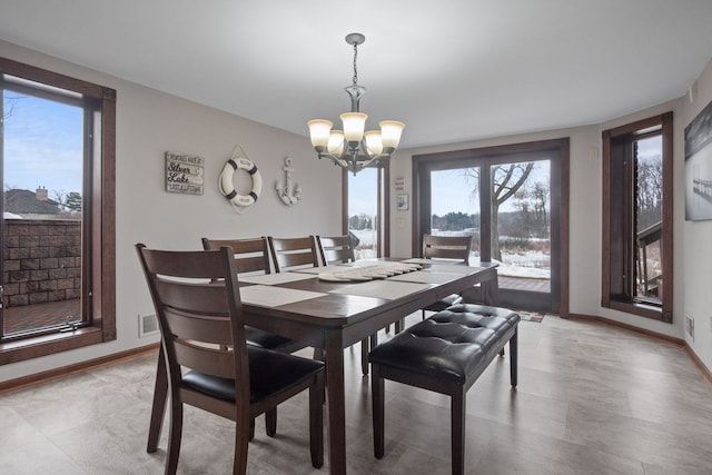 dining room featuring baseboards and an inviting chandelier