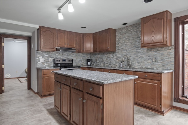 kitchen featuring ventilation hood, light stone countertops, decorative backsplash, stainless steel range with electric cooktop, and a sink