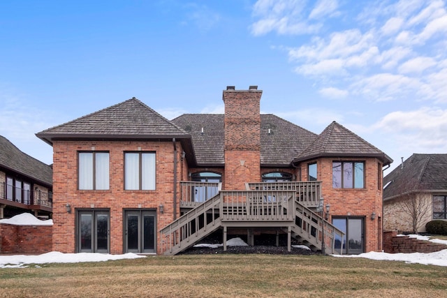 rear view of house with brick siding, a chimney, stairs, and a yard