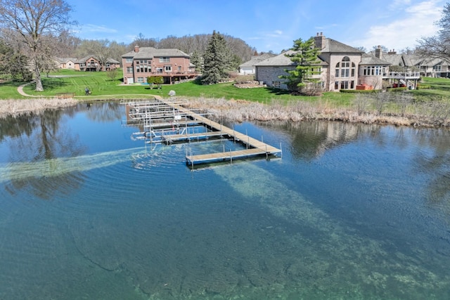 view of dock featuring a lawn and a water view