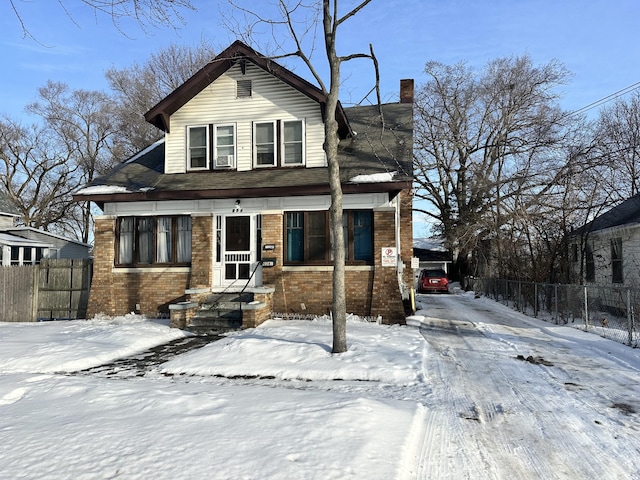 view of front of house with brick siding, fence, and a chimney