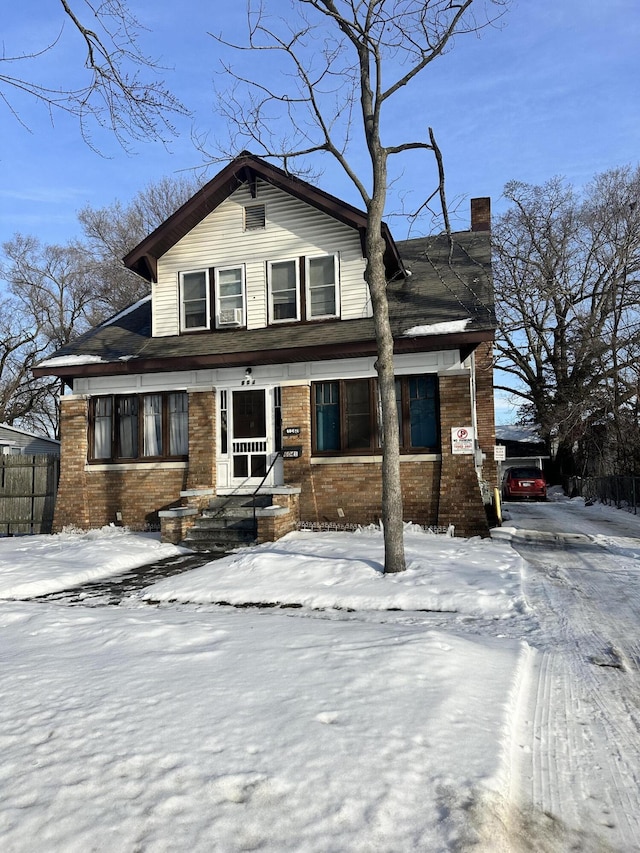 view of front of house featuring brick siding and a chimney