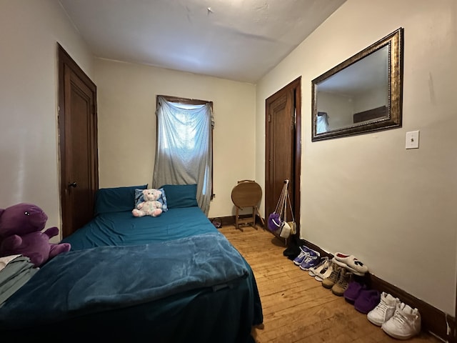 bedroom with baseboards and light wood finished floors