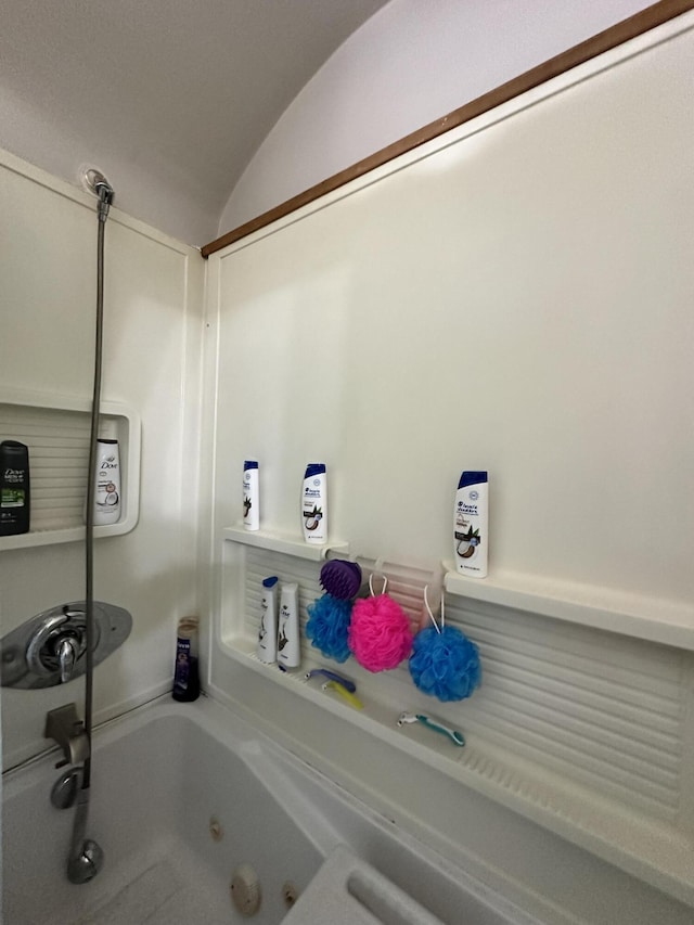 full bathroom featuring vaulted ceiling and a jetted tub