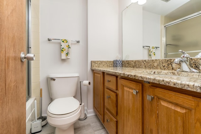 bathroom featuring shower / bath combination with glass door, vanity, and toilet