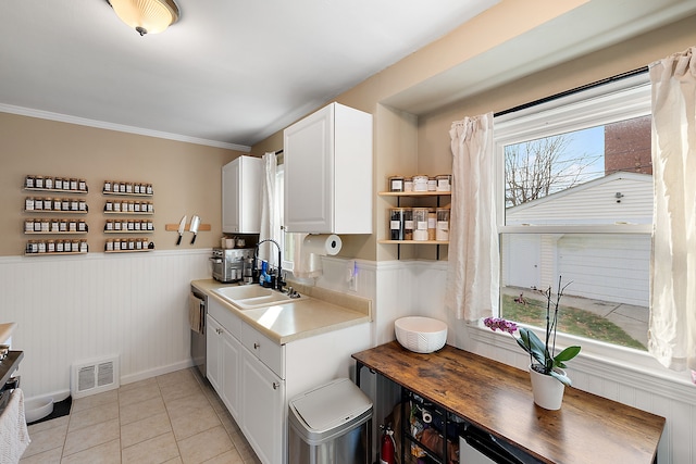 kitchen with light countertops, white cabinetry, a sink, and visible vents