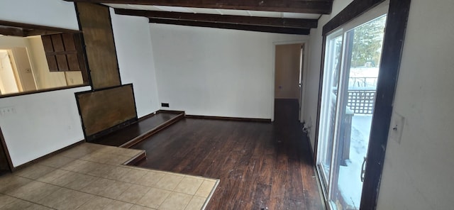 spare room with dark wood-style floors, vaulted ceiling with beams, and baseboards