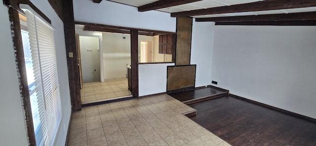 kitchen with baseboards, beamed ceiling, and light tile patterned flooring