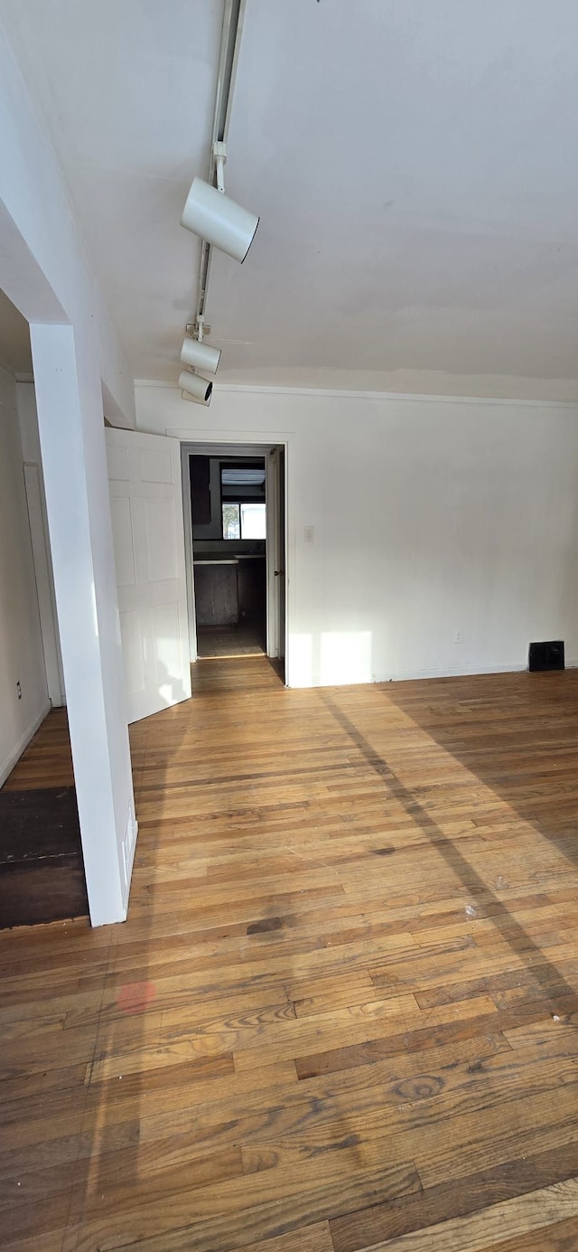 spare room featuring wood finished floors and rail lighting