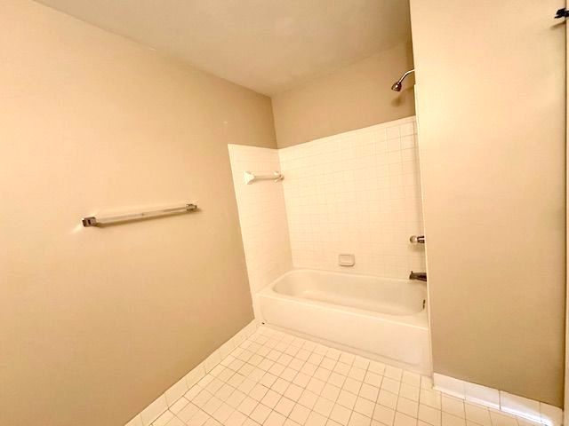 bathroom featuring tile patterned flooring and bathing tub / shower combination