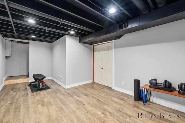 finished below grade area featuring baseboards, visible vents, and light wood finished floors