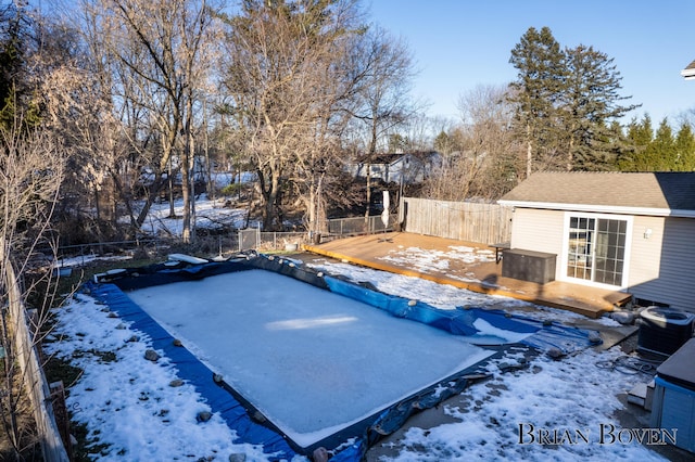 snow covered pool featuring a fenced backyard and central AC unit