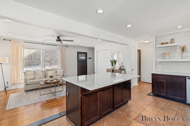 kitchen featuring dark brown cabinetry, a kitchen island, a ceiling fan, and recessed lighting