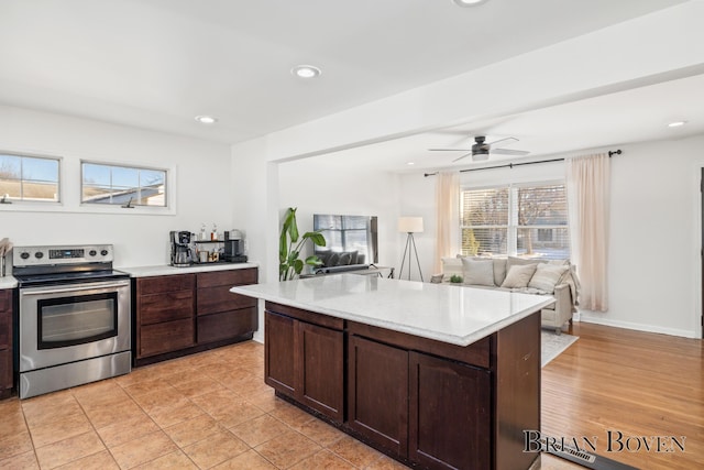 kitchen with open floor plan, dark brown cabinets, recessed lighting, and stainless steel range with electric cooktop