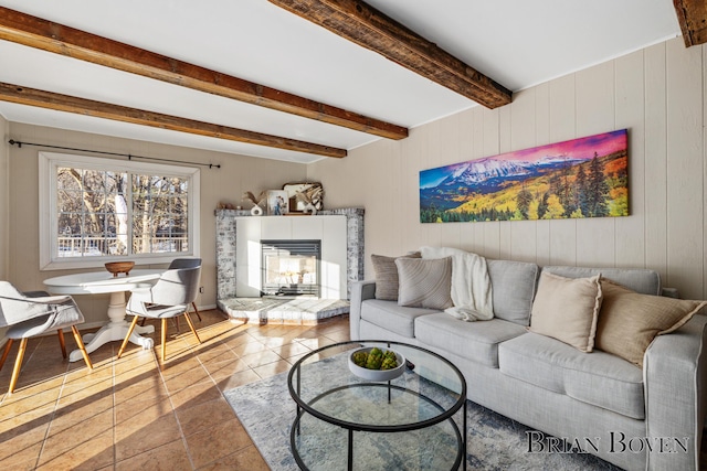 tiled living area with a glass covered fireplace and beamed ceiling