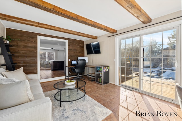 living area featuring wood walls, tile patterned flooring, wine cooler, and beam ceiling