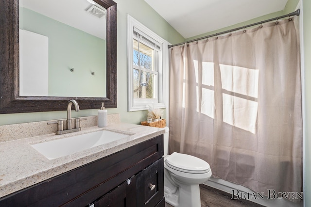 full bath featuring toilet, wood finished floors, vanity, and visible vents