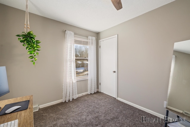 unfurnished bedroom featuring a textured ceiling, dark colored carpet, visible vents, and baseboards