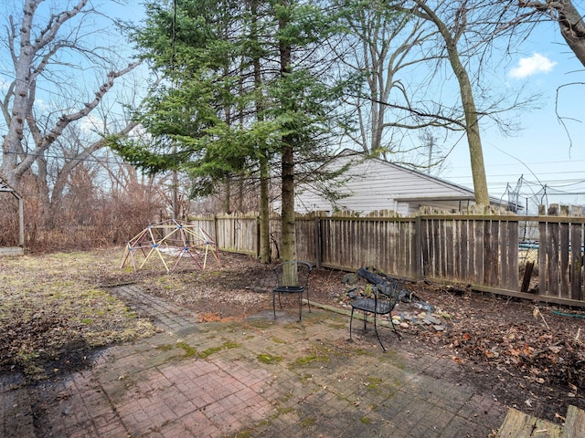 view of patio featuring a fenced backyard and a playground