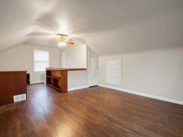 bonus room featuring dark wood finished floors, visible vents, vaulted ceiling, ceiling fan, and baseboards